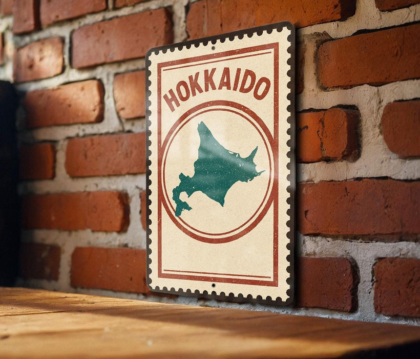 A vintage-style sign with the word "Hokkaido" on it, mounted on a brick wall.