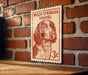 A Welsh Springer Spaniel dog is depicted on a red and white postage stamp, which is mounted on a brick wall.