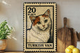A Turkish postage stamp featuring a cat is displayed on a shelf next to a wooden cutting board and some lemons.