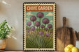 a framed illustration of purple chives on a shelf, with a wooden cutting board and a potted plant to the left.