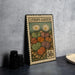 A metal stamp with a colorful illustration of various plants and flowers, including two daisies, is displayed on a table.