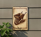 a wooden wheelbarrow with a decorative border, mounted on a wall.