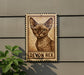 a wooden sign with a cat illustration on it, mounted on a wall.