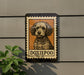 a sign with a dog illustration on it, mounted on a wall.