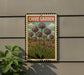 A metal sign with a vintage-style illustration of purple chives hanging on a wall, with a plant to the left.