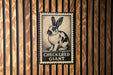 A metal sign with a rabbit illustration and the text "CHECKERED GIANT" is mounted on a wooden wall.
