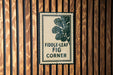 a sign with the text "Fiddle-leaf Fig Corner" on a wooden wall.