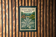 A poster for the "Dusting Miller Garden" is displayed on a wooden wall.