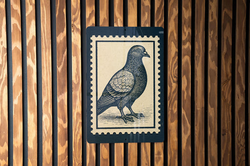 A postage stamp featuring a detailed illustration of a pigeon is displayed on a wooden wall.