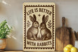a wooden sign with a rabbit illustration and the text "Life is better with rabbits" on a shelf.