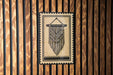 a decorative hanging piece with a geometric pattern, mounted on a wooden wall.