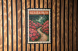 A framed image of a garden path with red flowers is displayed on a wooden wall.