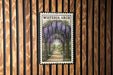 A framed image of a wisteria arch is displayed on a wooden wall.