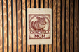 A sign with a chinchilla illustration and the text "CHINCHILLA MOM" is displayed on a wooden wall.