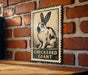 A sign featuring a rabbit on a brick wall, with the text "CHECKERED GIANT" below the image.