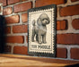 A metal sign featuring a poodle illustration is mounted on a brick wall.
