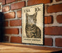 A metal sign featuring a cat illustration is mounted on a brick wall.