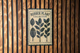 A sign for a rubber plant collection is displayed on a wooden wall.
