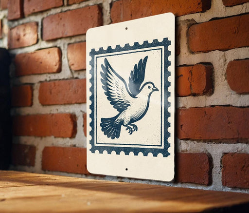 A white sign with a blue border and a black illustration of a bird in flight is hanging on a brick wall.