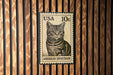 A US 10c postage stamp featuring an illustration of an American Shorthair cat.
