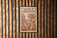 a stamp-like sign with the text "EDIBLE LANDSCAPING" and an illustration of a garden scene with various vegetables and plants.