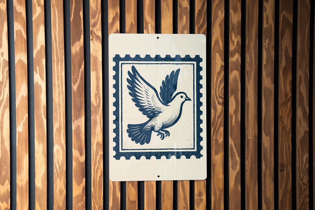 A sign featuring a blue bird in flight, with a postage stamp-like border, is displayed on a wooden wall.