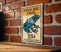 A vintage-style sign advertising a poison dart frog for 25 cents, mounted on a brick wall.