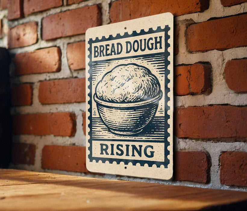 A sign with the text "BREAD DOUGH RISING" is displayed on a brick wall, with a wooden table below it.