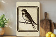 a wooden cutting board, a potted plant, and a sign depicting a bird perched on a branch.