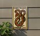 a sign with a large, colorful snake on it, mounted on a wall.