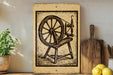 a wooden spinning wheel with a wooden bench in front of it, placed on a wooden shelf next to a potted plant and a wooden cutting board.