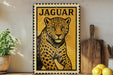 A framed poster of a leopard is displayed on a shelf, with a wooden cutting board and a potted plant to the left.