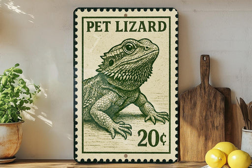 A metal sign featuring a drawing of a pet lizard, with the text "PET LIZARD" and "20¢" printed on it. The sign is placed on a wooden surface, with a potted plant, a wooden cutting board, and some lemons nearby.