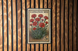 A vintage-style postage stamp featuring a bouquet of red carnation flowers, mounted on a wooden wall.