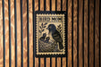 A black and white illustration of a bird, likely a mother bird, with her two young birds in a nest, is displayed on a wooden wall.