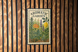 a decorative sign for an aromatic garden, with a floral and citrus theme, mounted on a wooden wall.