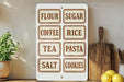 a kitchen counter with a white sign displaying various food items and a wooden cutting board.