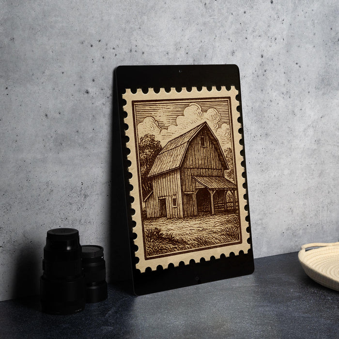 a wooden barn with a porch, depicted on a black frame with a decorative border.