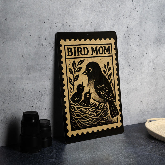A framed poster with a black and white illustration of a bird and its nest, along with the text "BIRD MOM" on the poster.
