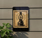 a black and white illustration of an oil lamp on a wall, with a decorative border around it.