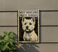 A framed image of a white terrier dog, with the text "WEST HIGHLAND WHITE TERRIER" printed on the frame.