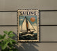 a vintage-style metal sign with a sailboat illustration, mounted on a wall.