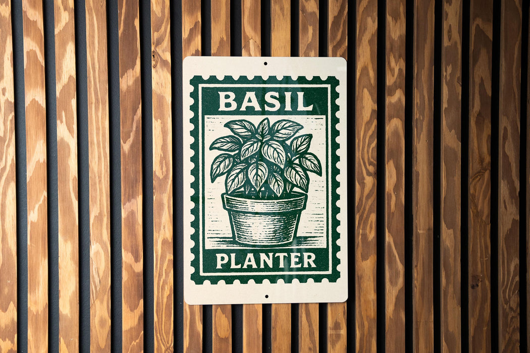 A green and white sign with the word "BASIL" and "PLANTER" printed on it, mounted on a wooden wall.