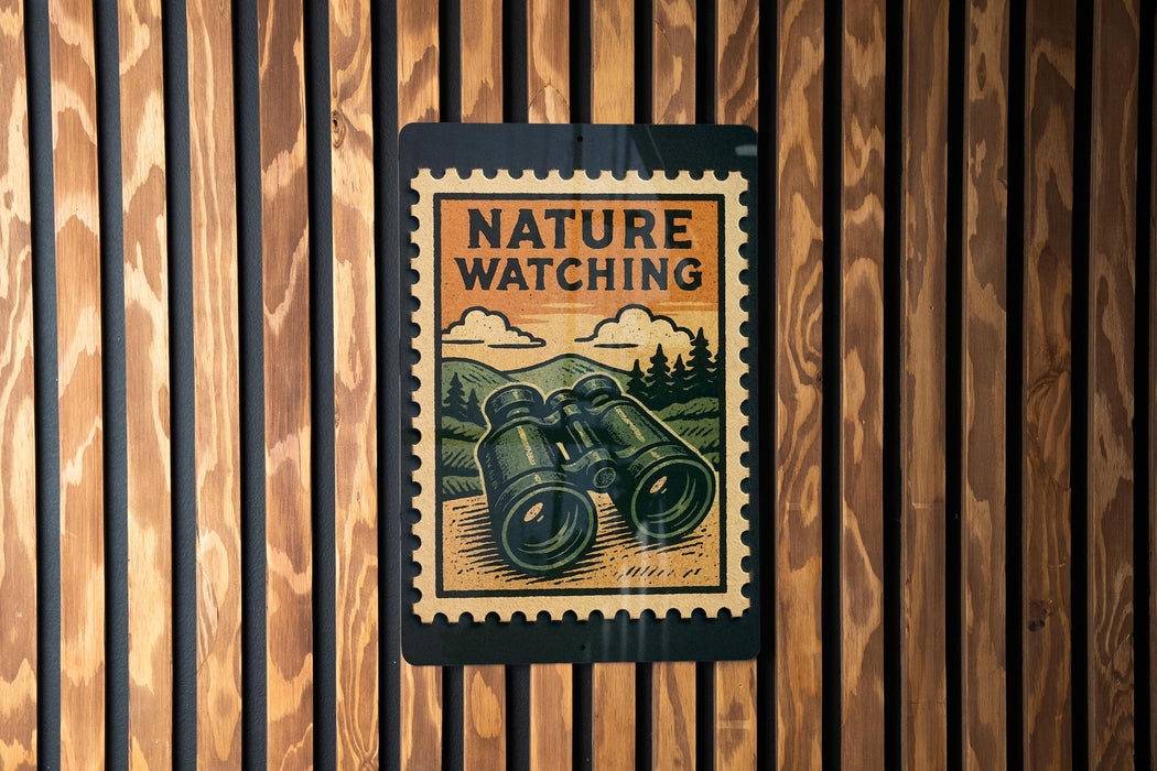 A vintage-style nature watching poster is displayed on a wooden wall, featuring a pair of binoculars and a scenic landscape.