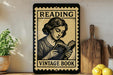 a vintage-style sign that reads "Reading Vintage Book" with a woman reading a book. The sign is placed on a shelf next to a wooden cutting board and a potted plant.