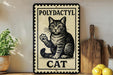 A vintage-style metal sign with a cat illustration, placed on a wooden surface next to a wooden cutting board and some lemons.