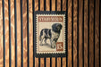 A stamp-like sign featuring a dog illustration and the text "STABHOUN" and "15c" printed on it, mounted on a wooden wall.