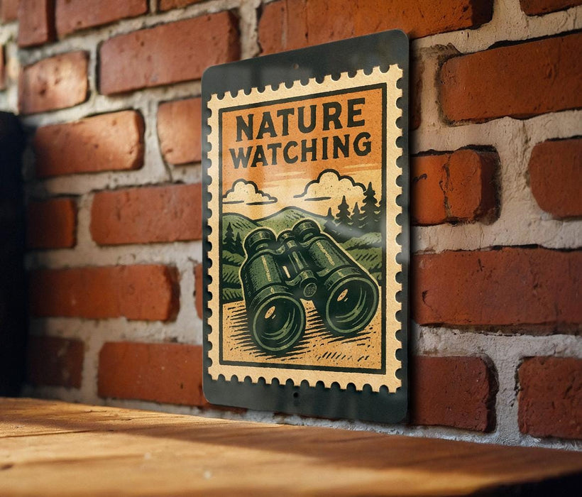 A vintage-style metal sign with a pair of binoculars on it, mounted on a brick wall.