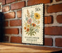 A 50 cent postage stamp featuring a floral bouquet is displayed on a brick wall.