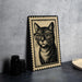 A framed illustration of a cat wearing glasses is displayed on a table, accompanied by a stack of black camera lenses and a woven basket.